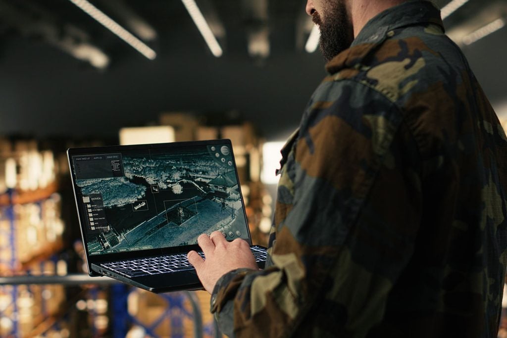 Military soldier ensuring surveillance in secure warehouse.